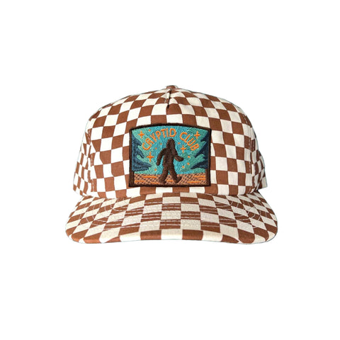Checkered cap with a Bigfoot "Cryptid Club" patch on a white background