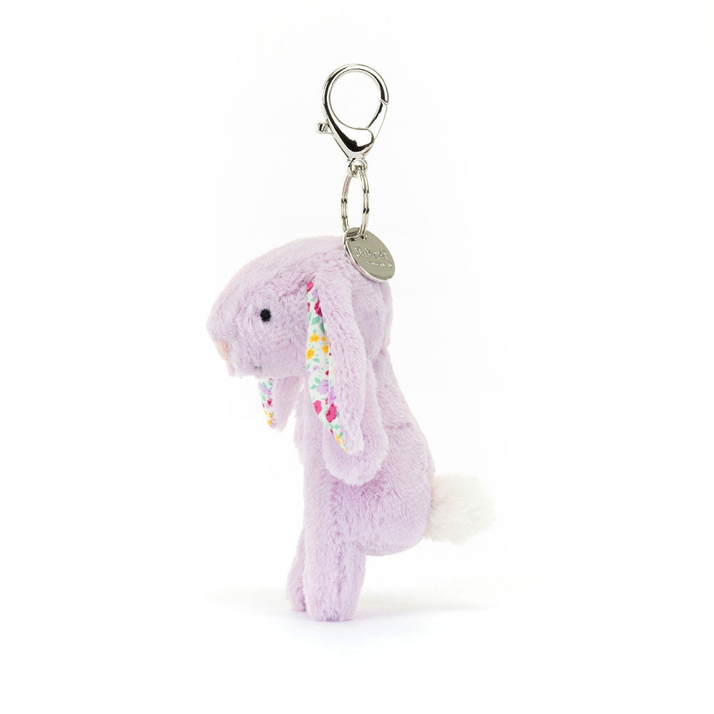 Side view of stuffed lavender colored bunny with floral fabric inside ears hanging from clip keychain