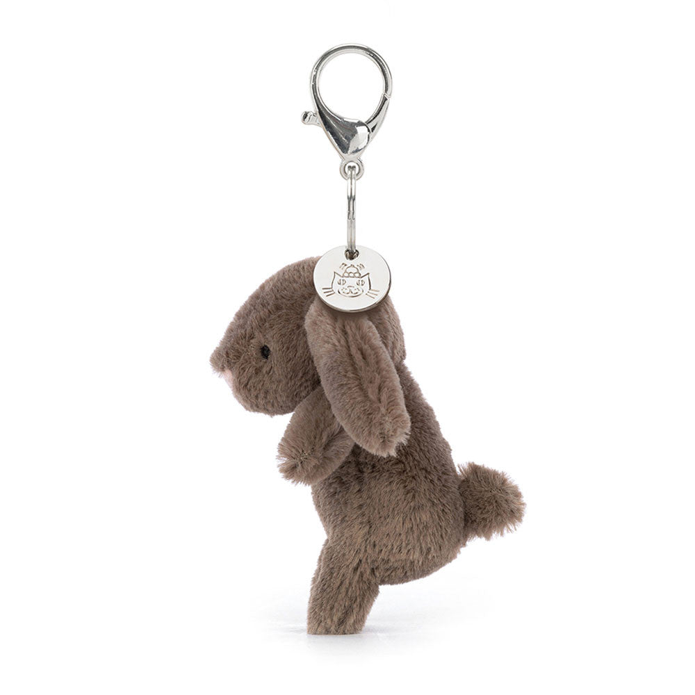 The side view of a stuffed brown bunny hanging from a clip keychain