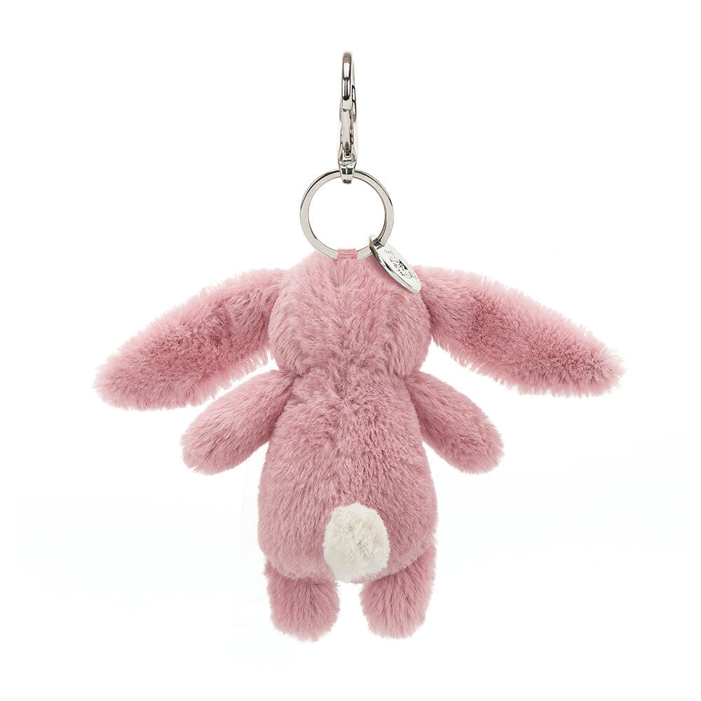 The back view of a light pink stuffed bunny hanging from a clip keychain