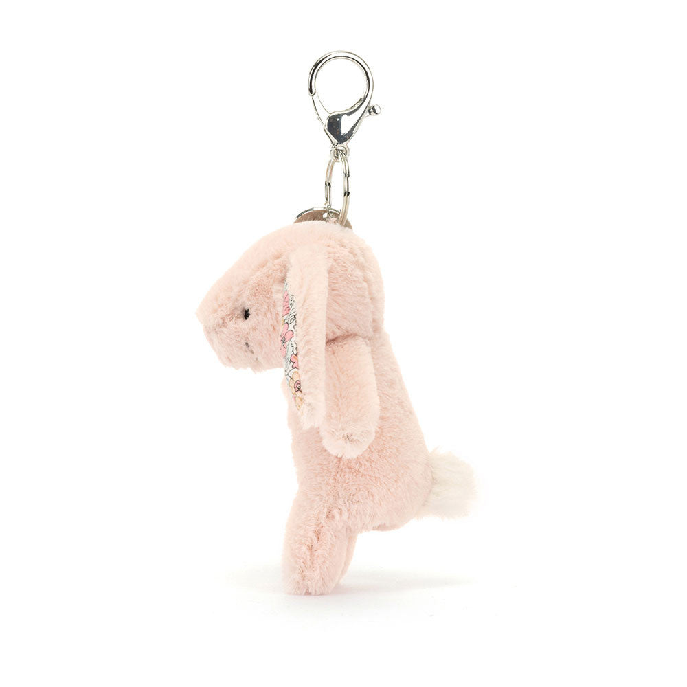 Side view of Stuffed blush bunny with floral fabric inside ears hanging from clip keychain