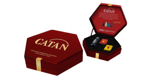 Red 'Catan' game box with game pieces on a white background