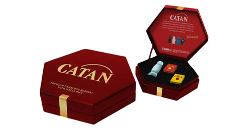 Red 'Catan' game box with game pieces on a white background