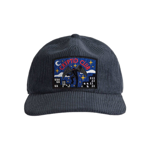 Navy corduroy cap with a Mothman 'Cryptid Club' patch on a white background