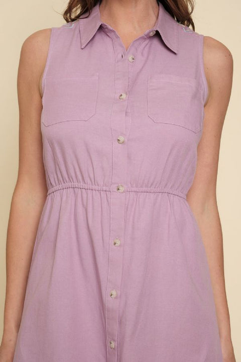 Lavender sleeveless dress with button details on a beige background