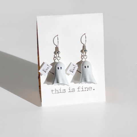 Image shows a pair of earrings hanging from silver wires. They are ghosts holding a sign that says "boo!"