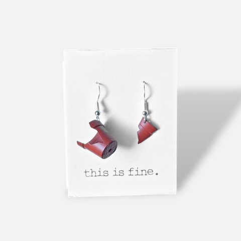 Image shows a pair of dangly earrings. They are two pieces of a broken red plant pot.