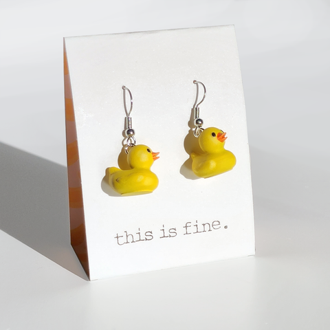 Image shows a pair of rubber ducky earrings hanging from silver wires