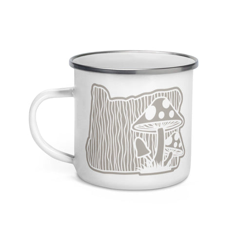 Image shows a white mug with a silver rim. The design is an outline of Oregon with a wood grain background and mushrooms on the right side.