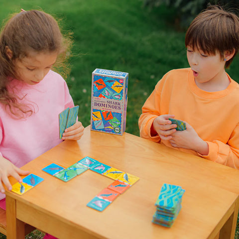 Image shows two children playing the dominoes game