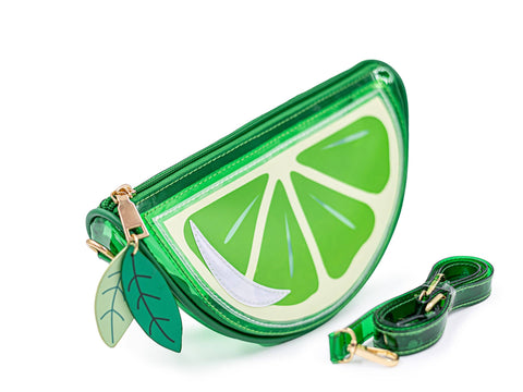 Image shows a jelly-like handbag styled as a slice of lime. It has a green strap in front of it.