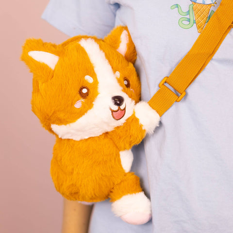 Imager shows an individual wearing the stuffed Corgi crossbody bag
