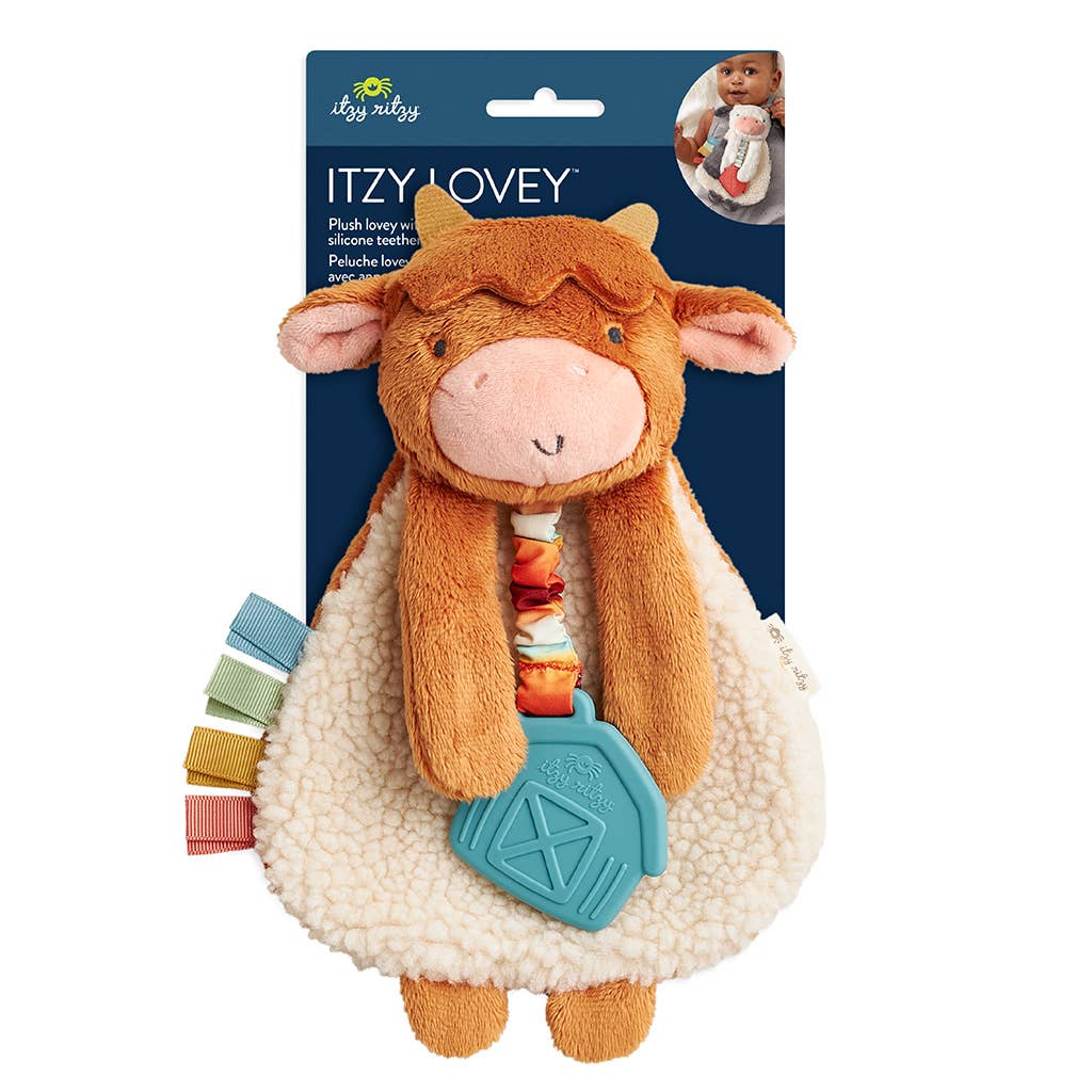 Image shows a sherpa lined highland cow with fabric tags hanging from its side and a rubber teether hanging from its neck