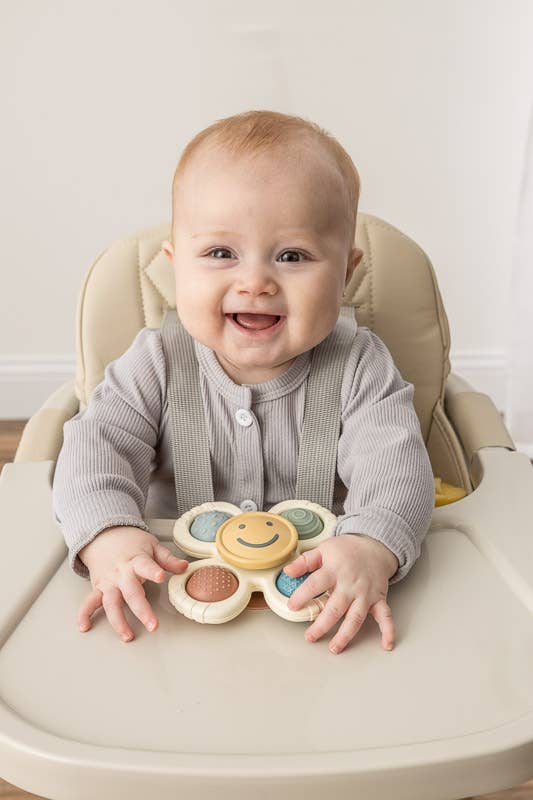 Image depicts a baby playing with the product on a high chair