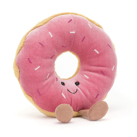 A stuffed donut with pink frosting and sprinkles.  The donut has a smiley face and feet.