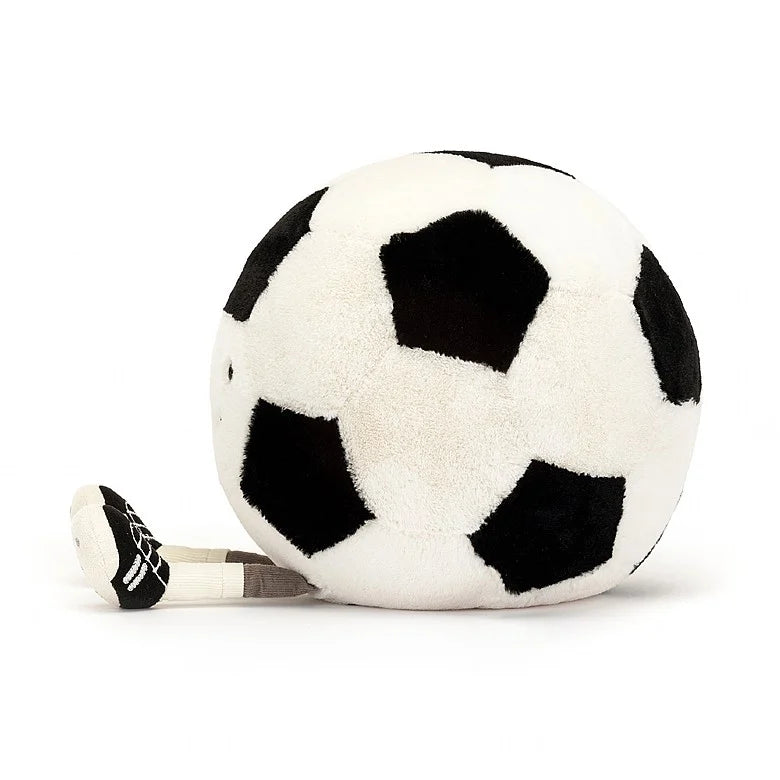 The side view of A stuffed soccer ball with a smiley face and feet wearing cleats