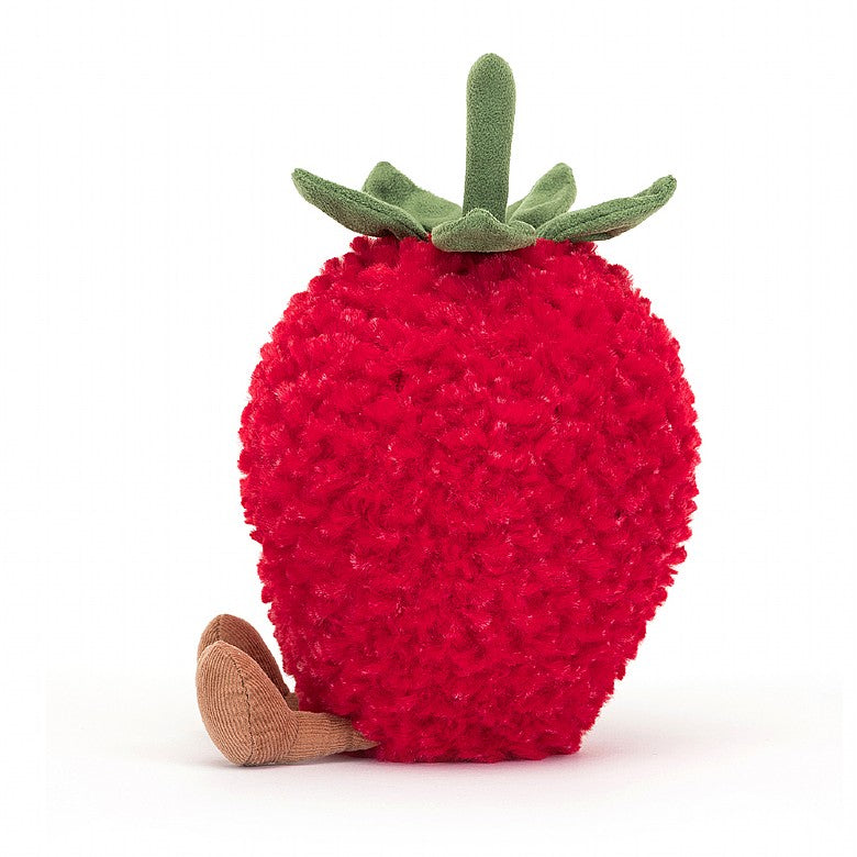 The side view of A stuffed strawberry with a smiley face and feet