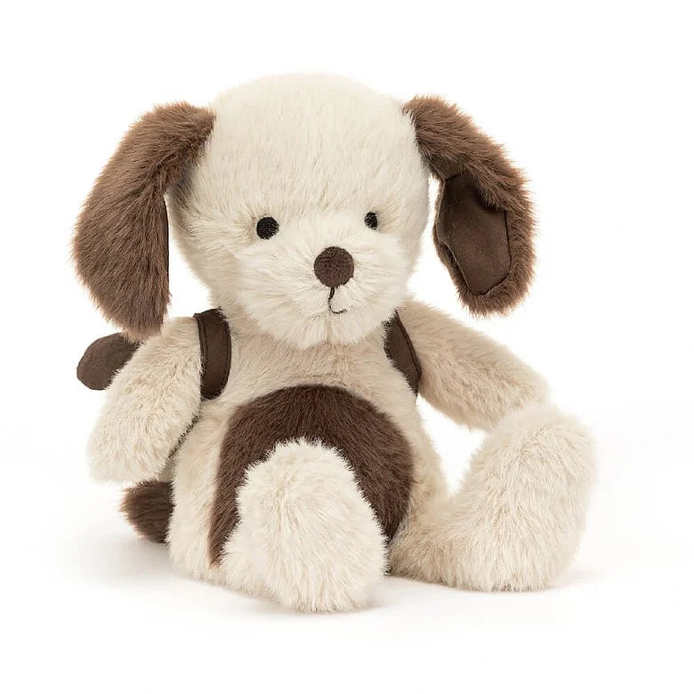 A stuffed brown and white puppy wearing a backpack