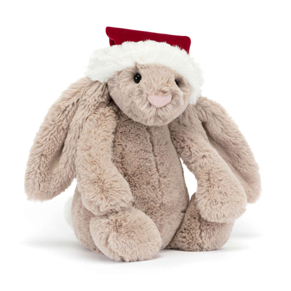 A beige stuffed bunny with floppy ears and a Santa hat