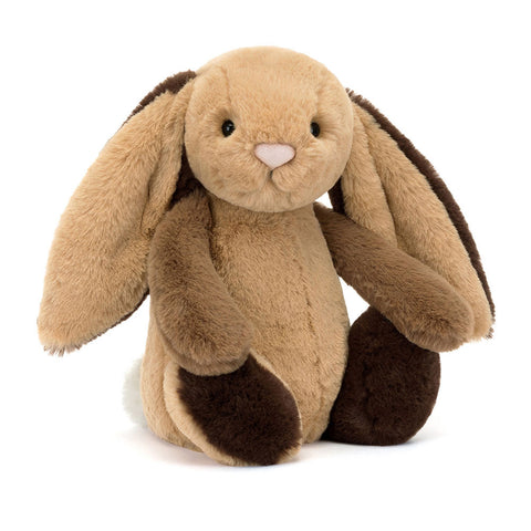 Image shows a honey-colored stuffed bunny with a dark brown foot, leg, and dark brown backs of his ears.