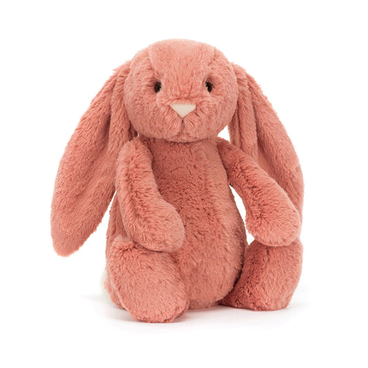 A coral pink bunny with floppy ears and a pink nose