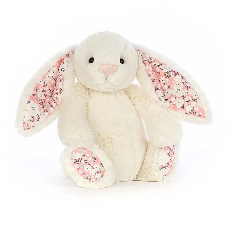 A white bunny with pink cherry blossom floral print inside its ears and on the bottom of its feet