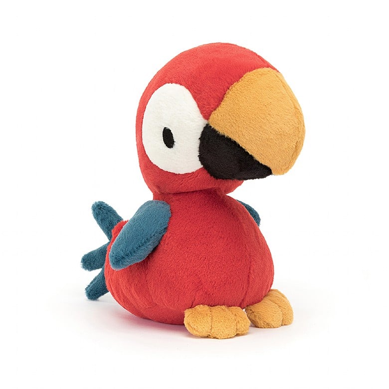 A red stuffed parrot with a yellow and black beak, white eye dots, and blue wings and tail