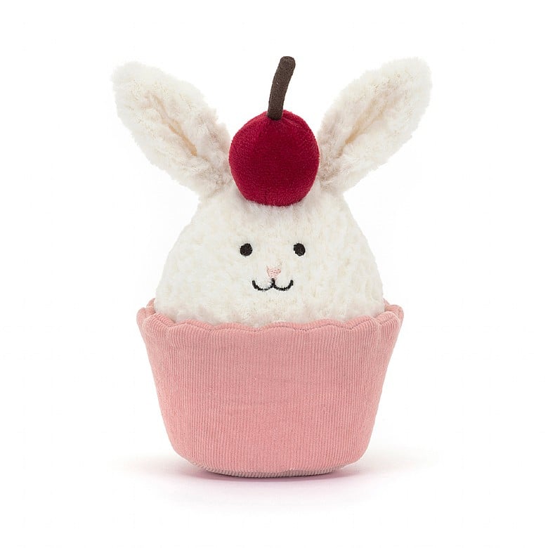 A bunny head inside a cupcake cup.  The bunny has a cherry on top of its head.