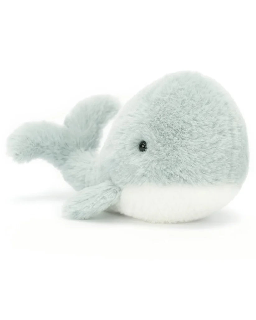 A small, light grey stuffed whale