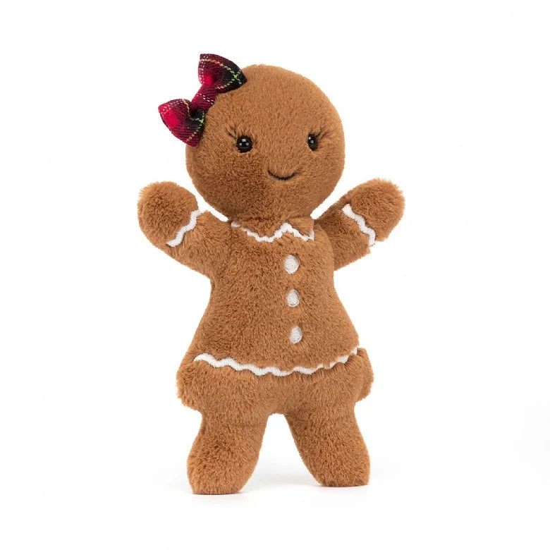 A stuffed gingerbread lady with white accents and a red plaid bow on her head