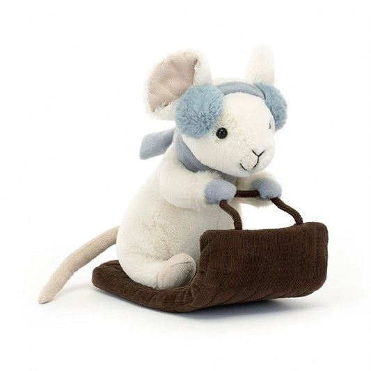 A white mouse on a sleigh. The house is wearing light blue mittens, earmuffs, and a scarf.