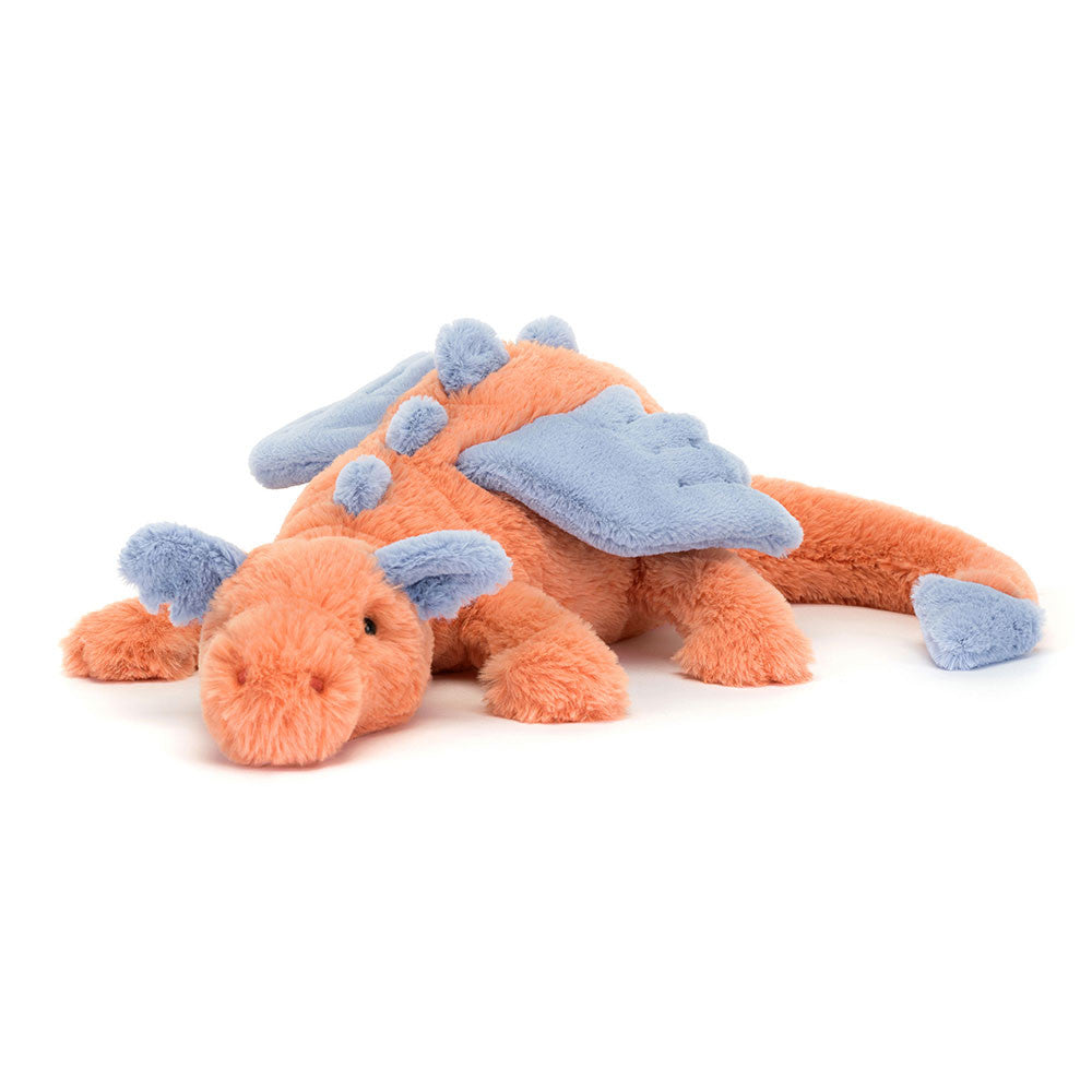 An orange stuffed dragon with light purple ears, spikes, wings, and tail tip. The dragon is laying down.