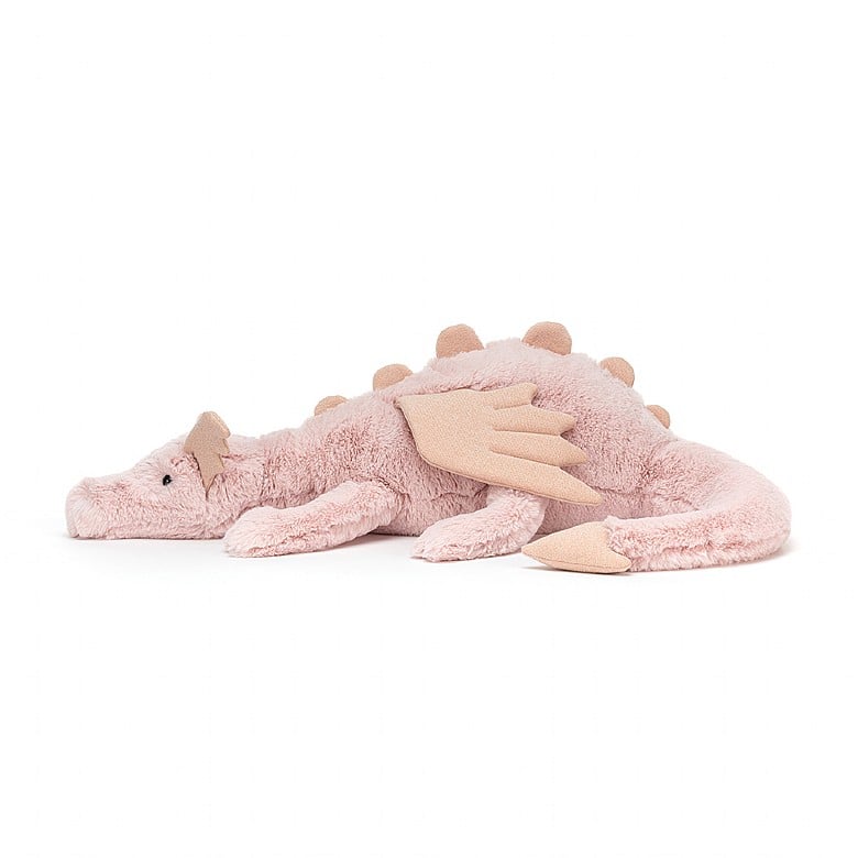 A side view of the light pink stuffed dragon