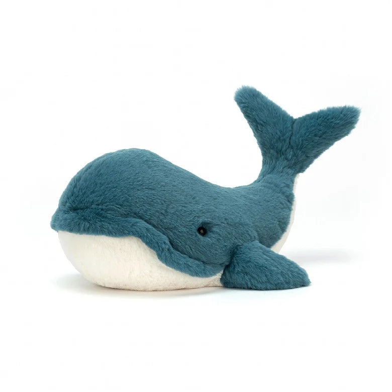 A stuffed whale with teal fur and a white underbelly