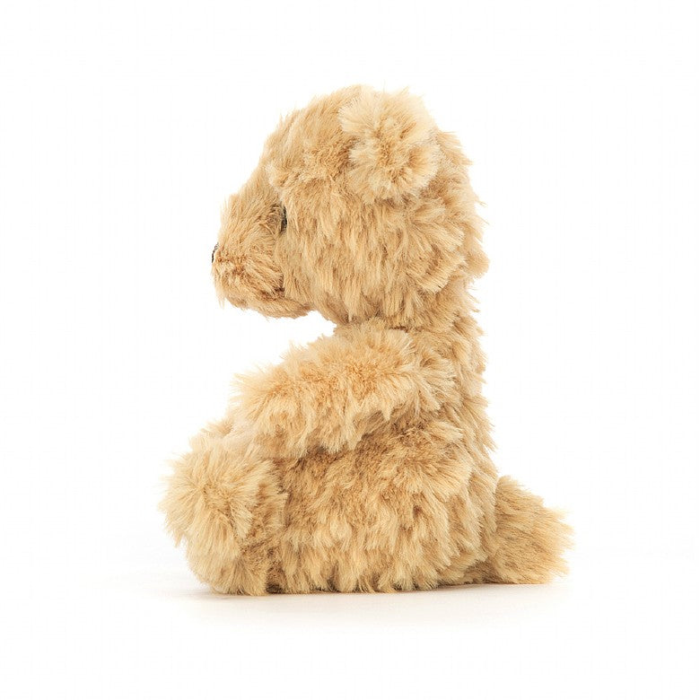 A side view of the tan tufty teddy bear