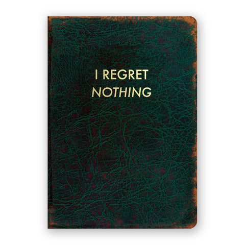 Image shows a green journal with gold text that reads "I regret nothing"
