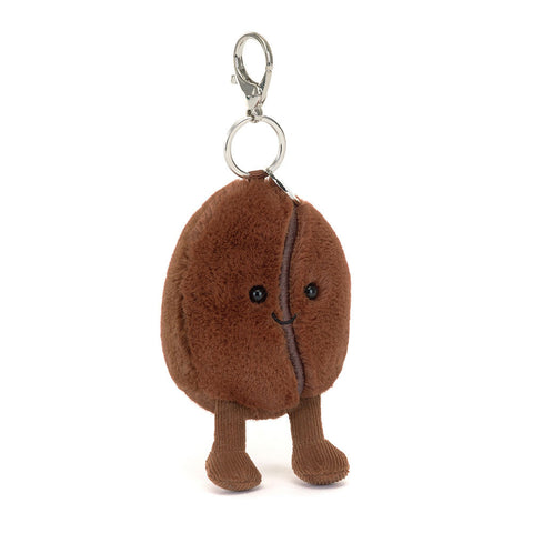 Image shows a stuffed coffee bean keychain. It has a happy face and feet. It has a silver clip keychain.