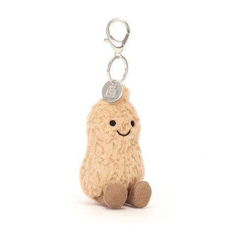 Image shows a stuffed peanut hanging from a silver clip keychain. It has a happy face and feet.