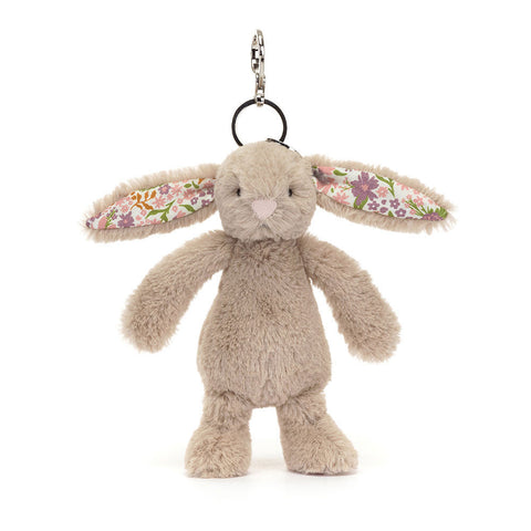 IMage shows a stuffed beige bunny attached to a keychain. Inside its ears is a floral pattern.