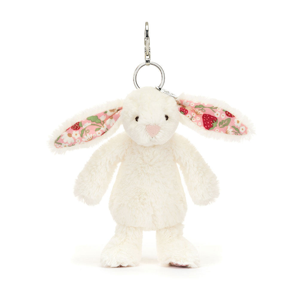 Image shows a white stuffed bunny attached to a keychain. Inside its ears is a strawberry print.