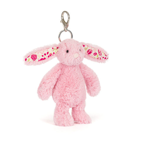 Pink plush bunny keychain with floral patterns in its ears on a white background