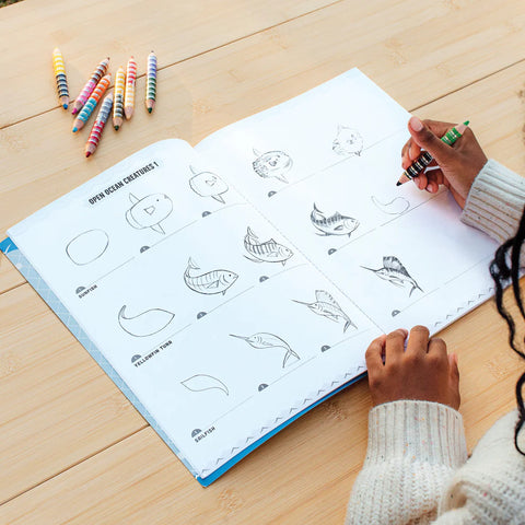 Image shows a young child using one of the learn to draw pages