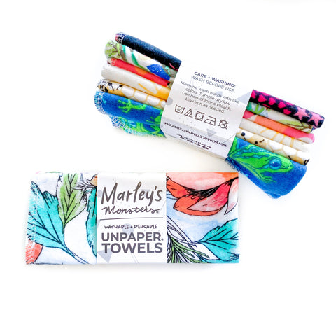 Image shows two six packs of fabric towels in assorted prints