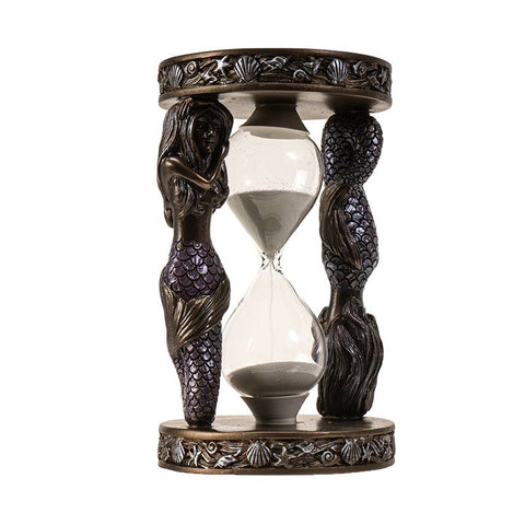 Image shows a resin sand timer with two Mermaids. One is right-side up and one is upside down. The base has various shells.