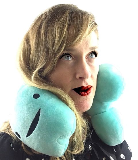 Image shows a woman with the penis neck pillow around her neck