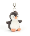 A fuzzy stuffed penguin hanging from a clip keychain