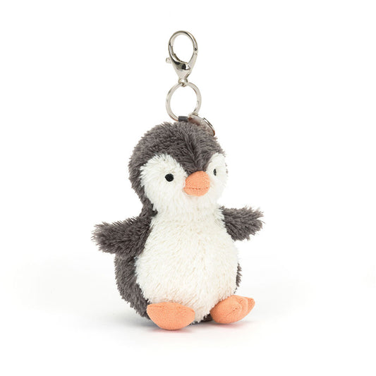 A fuzzy stuffed penguin hanging from a clip keychain