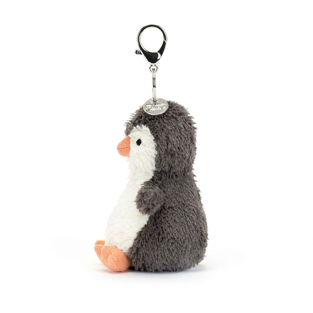 The side view of a fuzzy stuffed penguin hanging from a clip keychain