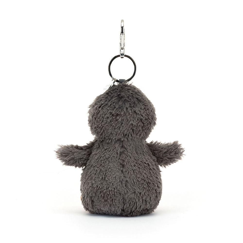 The back view of A fuzzy stuffed penguin hanging from a clip keychain