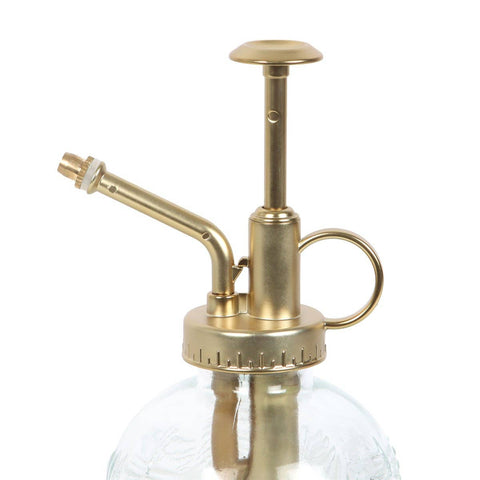 Image shows a close-up of the gold-colored metal top of the plant mister.